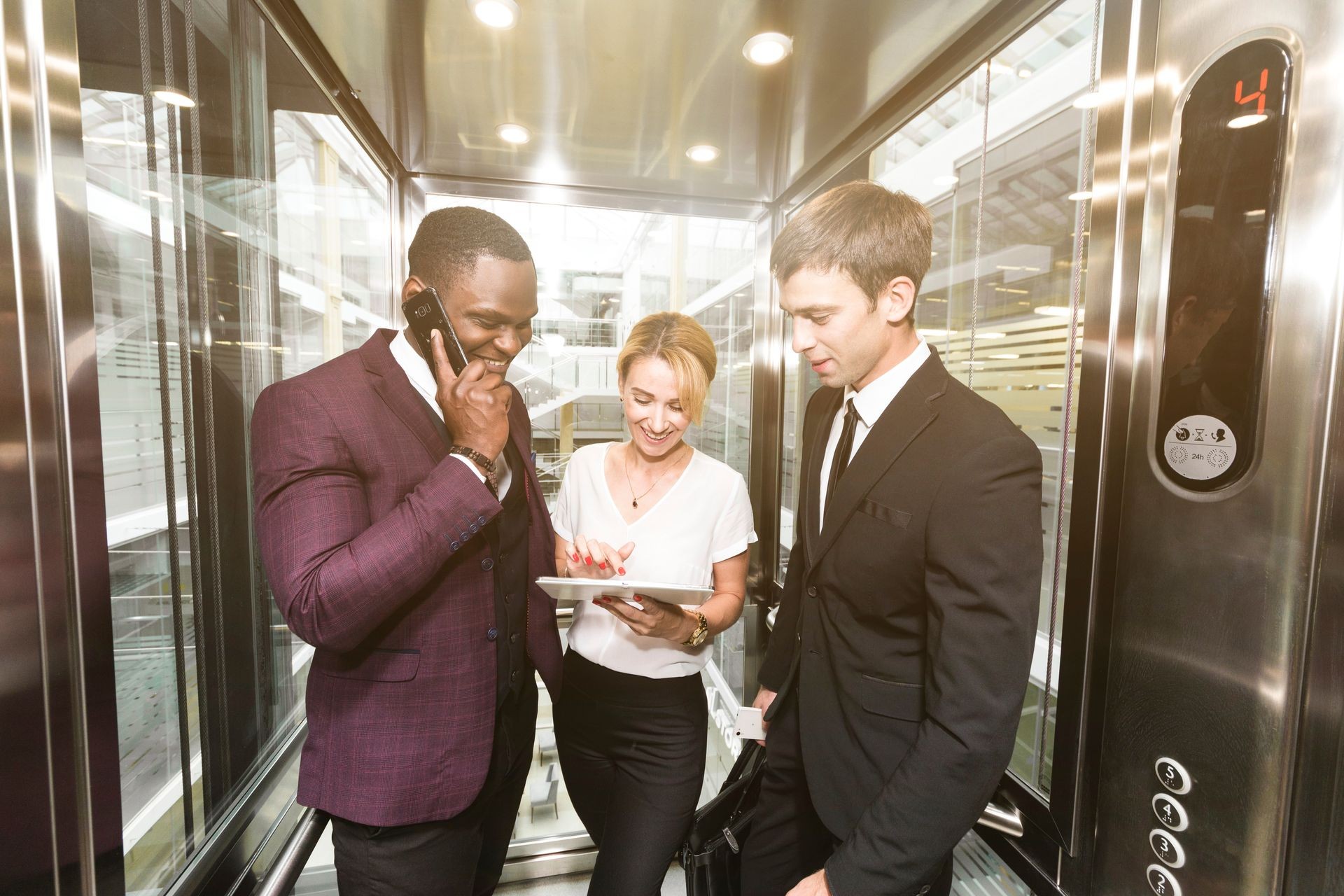 successful and young businessmen in the elevator business center rides to work
